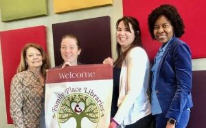 Members of the Bryan + College Station Public Library System staff show the new banner designating Larry J. Ringer Library as a Family Place Library.
