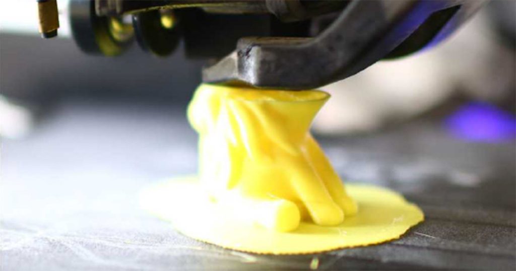 image of a 3d printers creating a yellow form.