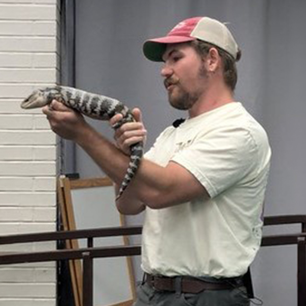 presenter holding up a large reptile for display