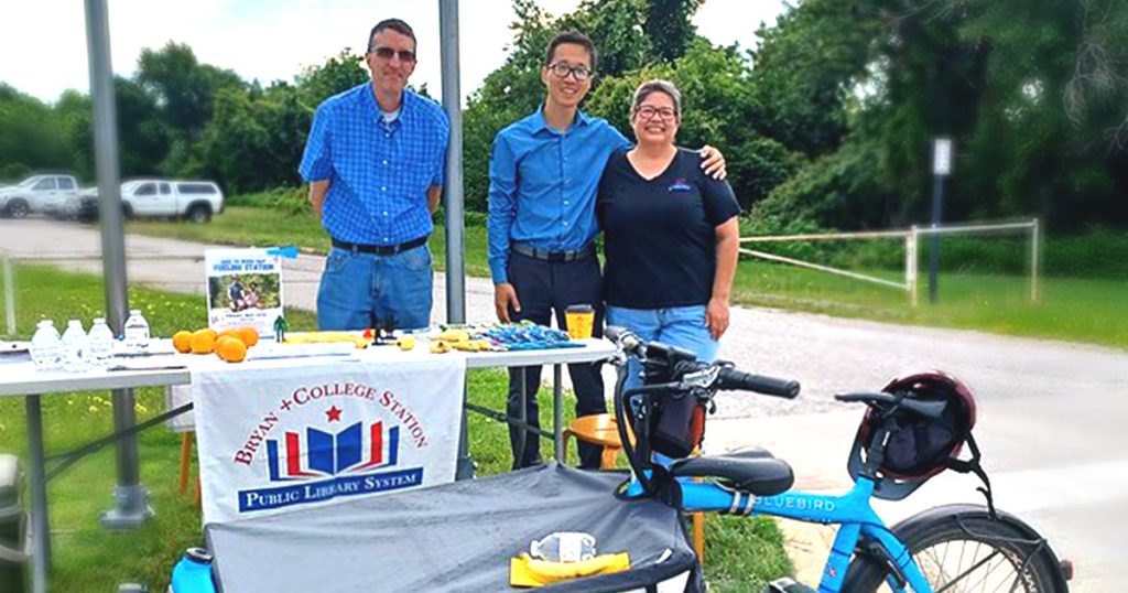 volunteers and staff smiling and standing by the refueling station table