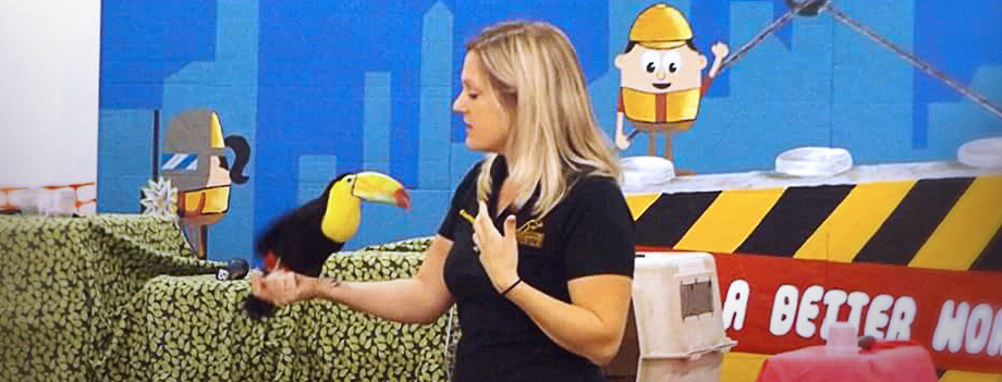educator presenting with a toucan perched on her arm