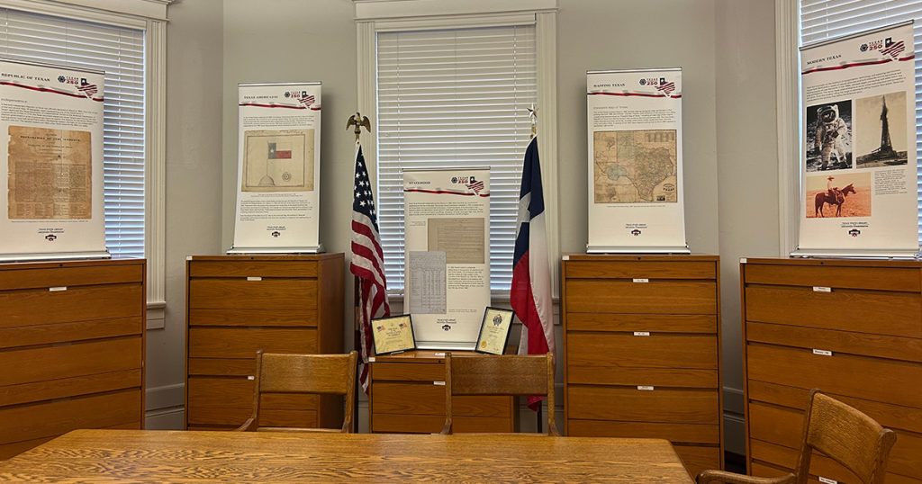America250 Traveling Exhibit posters and flags shown on top of cabinets at the Carnegie History Center.