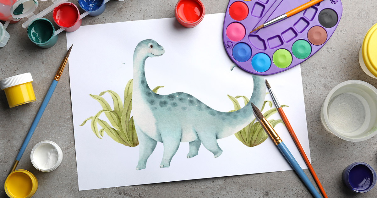 painted dinosaur surrounded by art supplies
